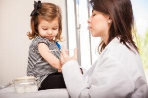 little girl getting a vaccination at a doctor's office