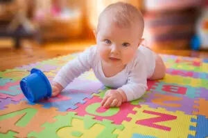 Baby laying on tummy playing with toy