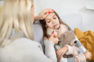 Mom taking child's temperature. 