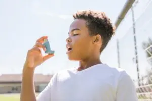 Child using inhaler at school. 